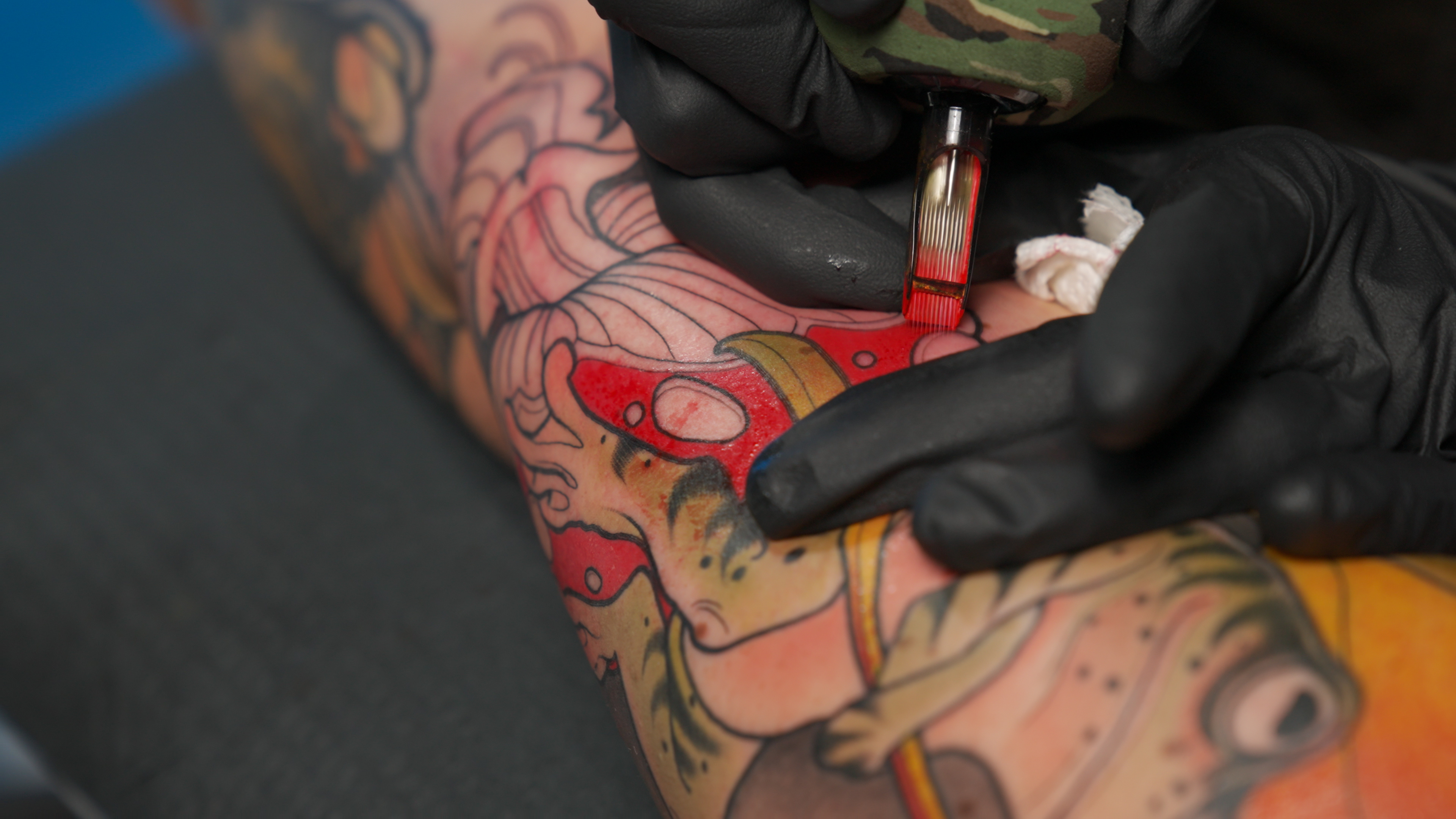 Needle packing saturated red on neo-traditional color sleeve, clean fills with no skin trauma